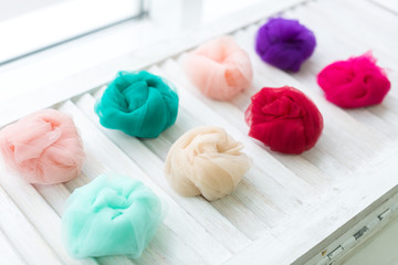 Color fabric on a white wooden background. Fabric Flowing Cloth. Wave, fatin. Pink, Blue Color. Spring colors on a white wooden background.