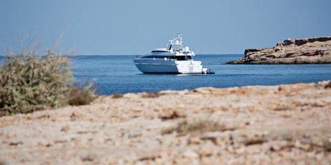 Yacht near coast at Ibiza. Beautiful place for diving. Holidays in the Mediterranean.