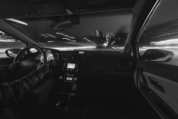 Car speed night drive on the road in city, black-and-white photo