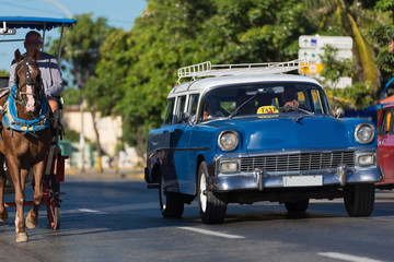 Blau weißer Oldtimer mit einer Pferdekutsche auf der Strasse in Varadero Kuba - Serie Kuba...