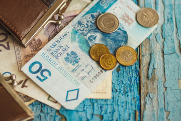 Polish zloty with wallets on the old wooden background