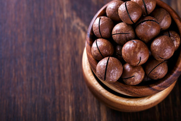 Macadamia Nut in Shell on Wooden Background.Vegetarian.Concept of Healthy Food.Copy space for Text.selective focus.