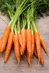 Fresh and sweet carrot on a grey wooden table.