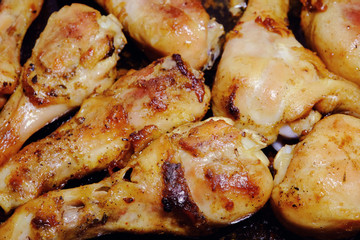 Chicken fast food. Grilled chicken on a baking tray in the background. Fatty food.
