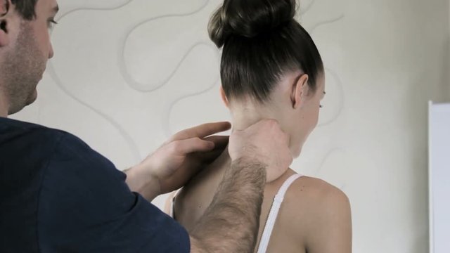 Doctor manual therapist gropes patient's neck and spine girls