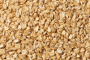 Oatmeal raw flakes close up textured background.