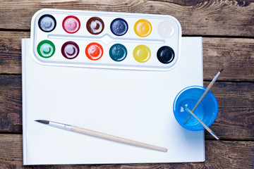 palette of watercolor paints, brushes