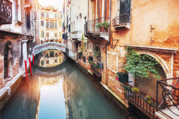 Fototapeta na wymiar Traditional Gondolas on narrow canal between colorful historic houses in Venice Italy