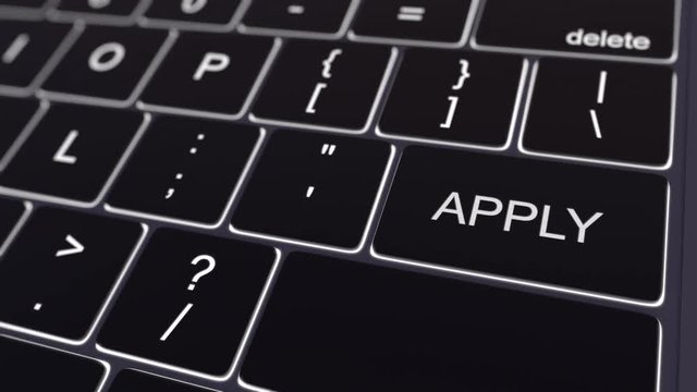 Dolly shot of black computer keyboard and glowing apply key. Conceptual 4K clip