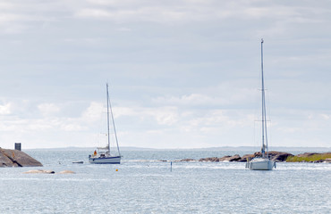 Two sailboats on the glittering blue sea a summer day