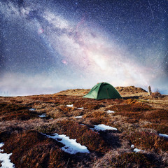 the starry sky above the tent in the mountains. Magic event in f