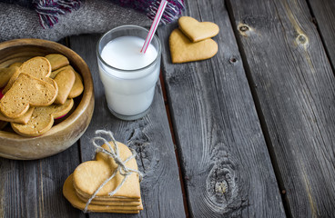 Valentines day heart shaped cookies and glass of milk.
