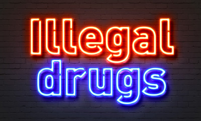 Illegal drugs neon sign on brick wall background.