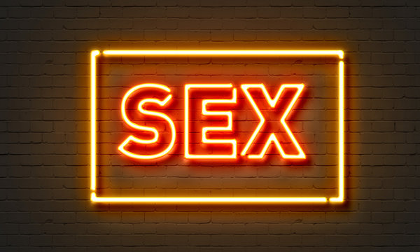 Sex neon sign on brick wall background.