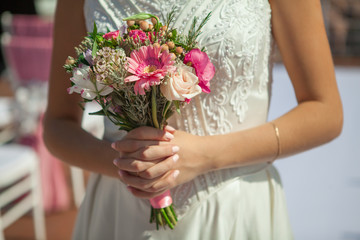 Obraz na płótnie Canvas Bride holding small wedding bouquet in hands