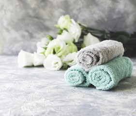 Fototapeta na wymiar stack of towels with flowers for spa space under the text, selective focus