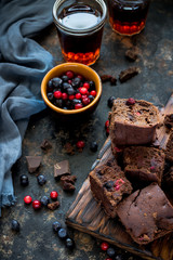 Brownie pieces with berries on dark blue background.