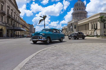 Fototapeta na wymiar Blauer und schwarzer amerikanischer Oldtimer auf der Hauptstraße in Havanna Kuba vor dem Capitolio - Serie Kuba Reportage