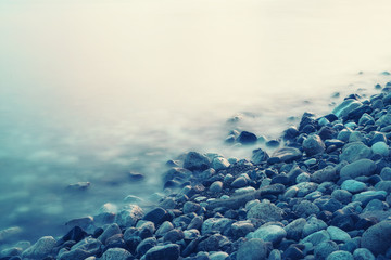 Dreamy natural background with sea shore, rocks and waves. Long exposure