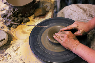 closeup of hands working on pottery wheel, clay pot 