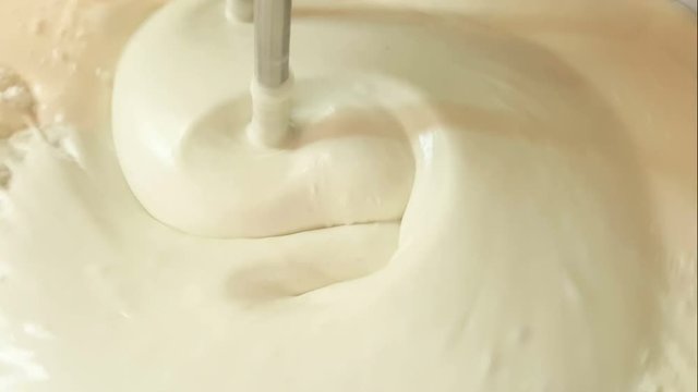 Close up of twist white cream spining add more flour and mixing color in the blow