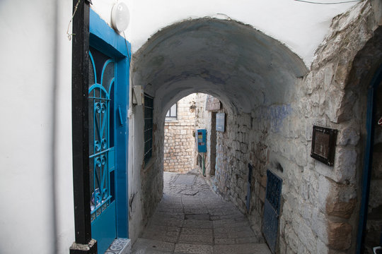 typical street of Safed with arch, stones and blue doors