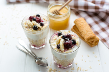 Healthy breakfast. Oatmeal with bananas, berries and honey