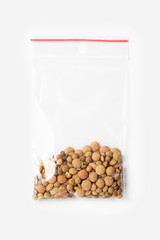 Plastic transparent zipper bag with a little lentils beans isolated on white, Vacuum package mockup with red clip. Concept