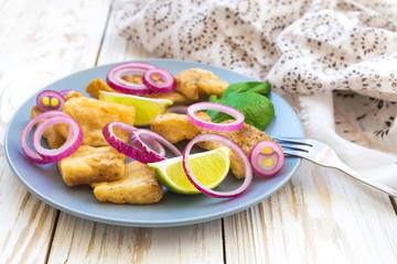 Crispy fried fish tilapia with lime and pickled onion