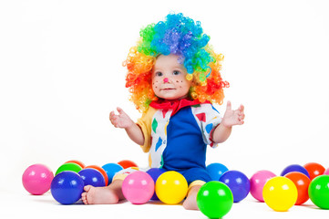 Fototapeta na wymiar Child clown with a red nose multicolored wig in with balls