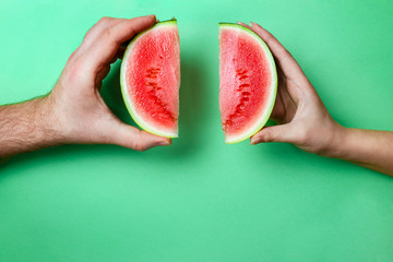 Slices Mini Watermelon in Female and Male Hands with Green Copy Space.