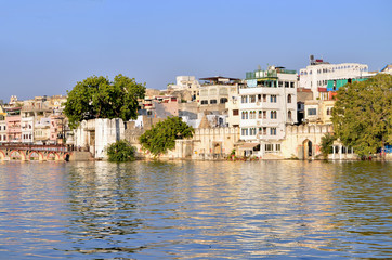Fototapeta na wymiar Beautiful landscape of the city on water at sunset in India Udaipur 