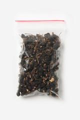 Plastic transparent zipper bag with home dry currant isolated on white, Vacuum package mockup with red clip. Concept.