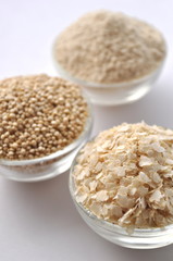 Quinoa in three forms - flour, flakes and grain. Alternative gluten-free grain. Isolated on white