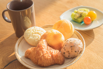 Bread and lots of fresh bread buns on a wooden table