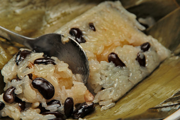 Streamed sticky rice and black bean in banana leaf .