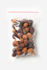Plastic transparent zipper bag with home dried briar isolated on white, Vacuum package mockup with red clip. Concept.
