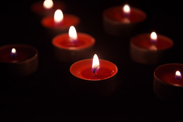 Red Burning candle isolated on black background.