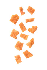 Falling sliced sheets of crispy pork on white background.