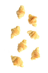 Falling mini croissants on white background.