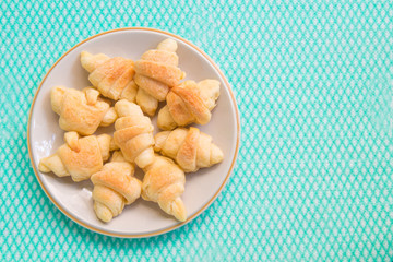 Mini croissants in plate on table.