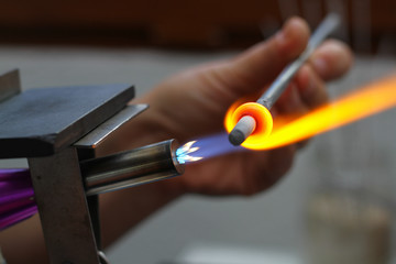woman's hands with tools for glass melting