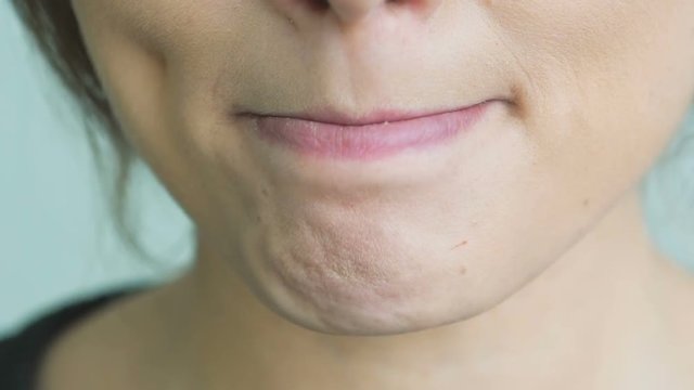 Extreme close up of woman licking and bitting lips. Slowly