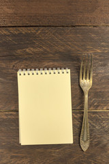 Vintage fork and notepad for copyspace, overhead shot