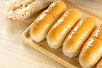 Hotdog buns in wood plate on wooden table