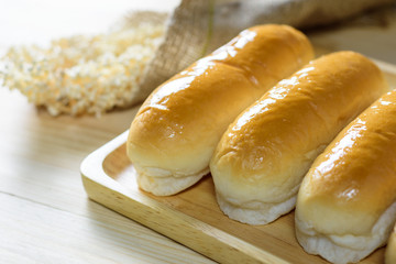 Hotdog buns in wood plate on wooden table