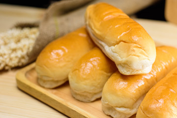 Hotdog buns in wood plate on wooden table