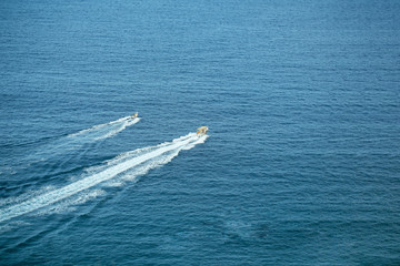 Fototapeta na wymiar Two speed motor boats or ships travel by sea