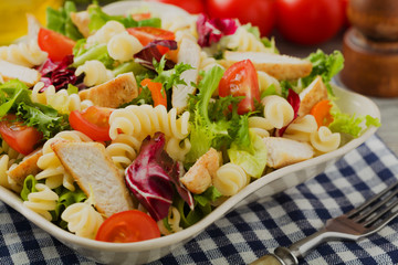 Noodle salad with green lettuce, tomatoes and roasted chicken.