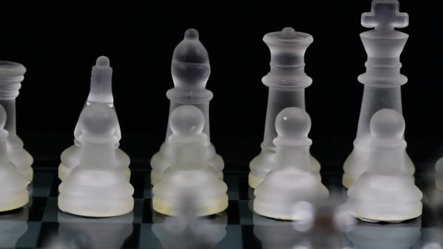 Tight Shot Of Glass Chess Pieces Set Up On Far Side Of Board
